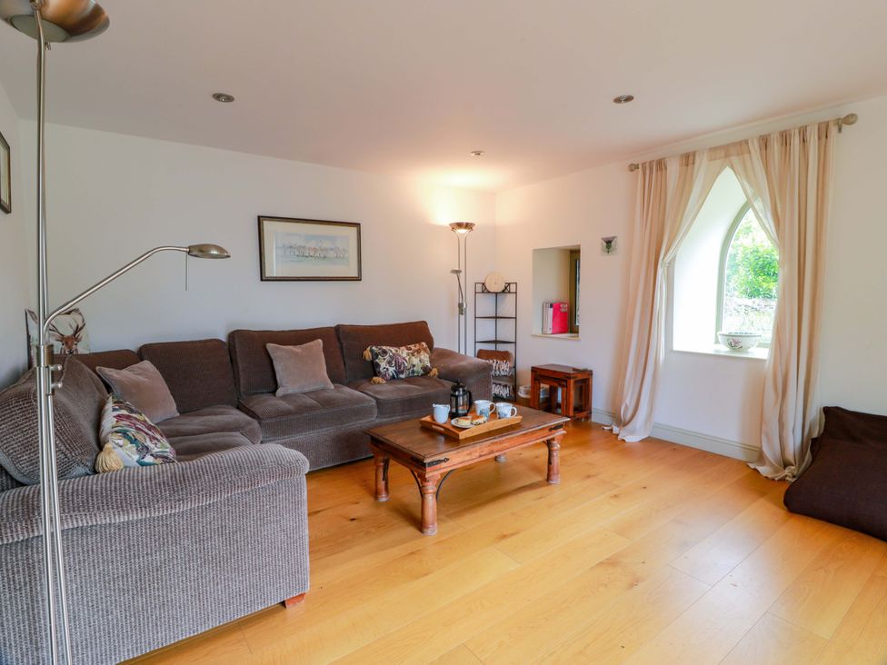 A living room with a sofa and coffee table at Muirmailing Cottage Plean near Stirling