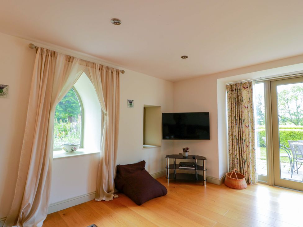 A living room with a window and television at Muirmailing Cottage Plean near Stirling
