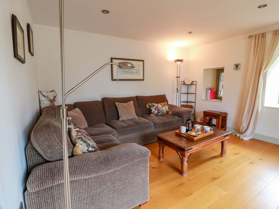 A living room with a sofa and coffee table at Muirmailing Cottage in Plean near Stirling