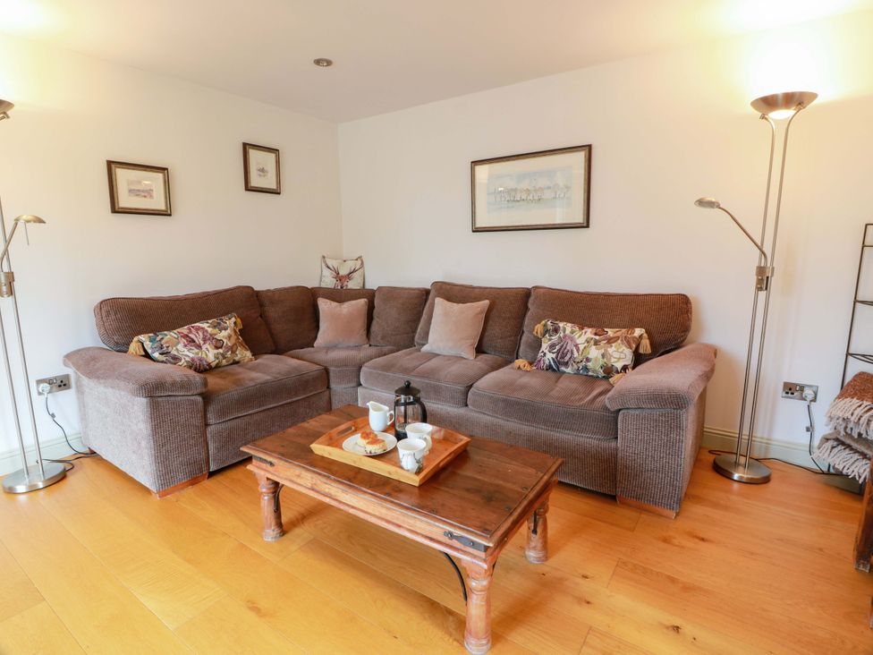 A living room with a sofa and coffee table at Muirmailing Cottage Plean near Stirling