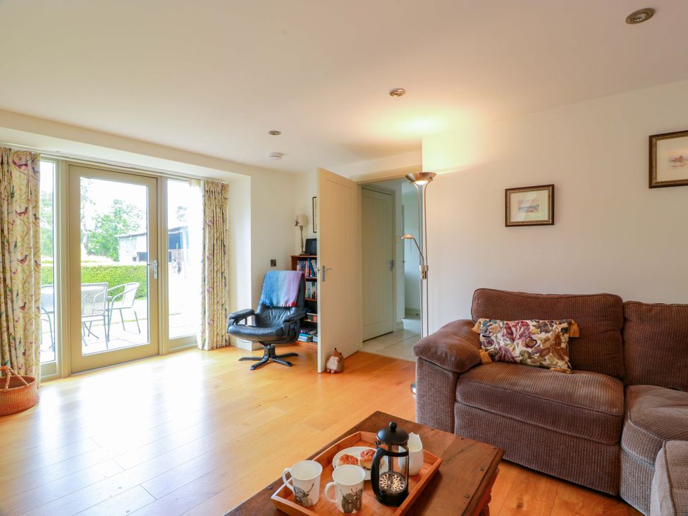 A living room with a sofa and a table at Muirmailing Cottage Plean near Stirling