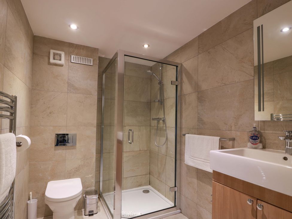 A bathroom with a shower, toilet, and sink at Muirmailing Cottage in Plean near Stirling