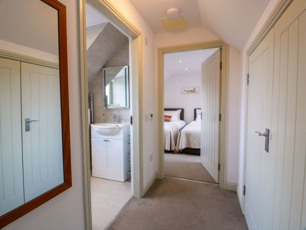 A corridor with doors leading to a bathroom and a bedroom at Muirmailing Cottage Plean near Stirling