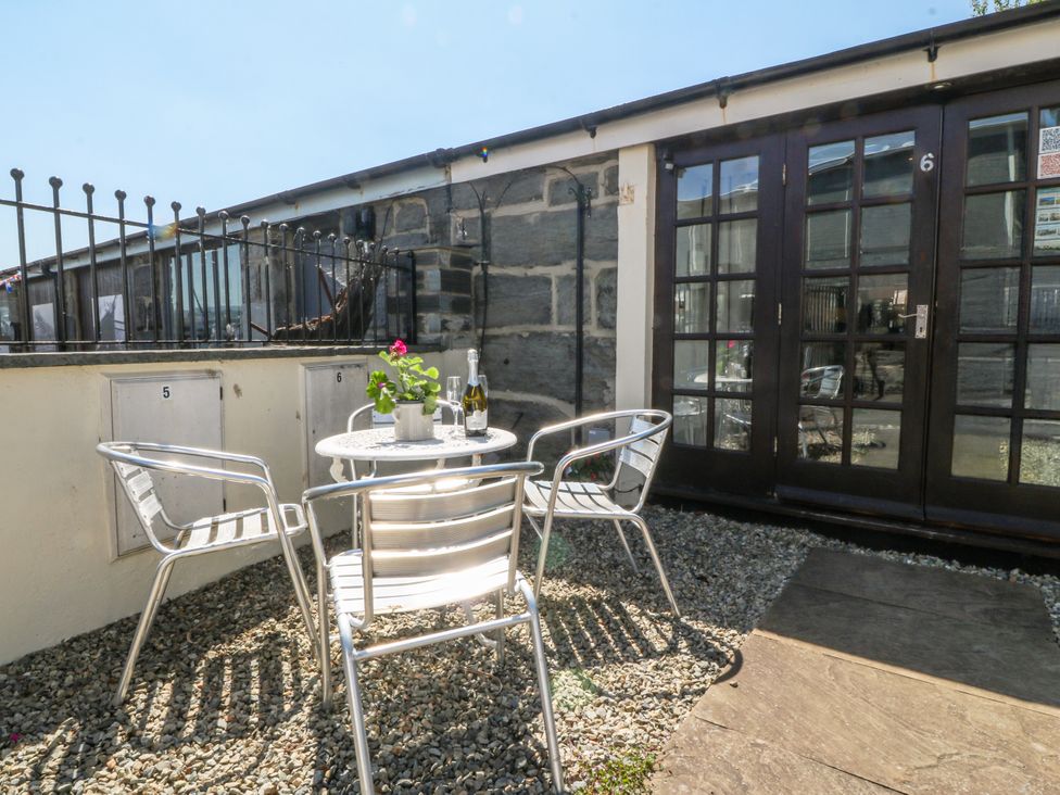 An outdoor seating area with a table and chairs at Maritime Mews, 6 The Oakleys, Porthmadog