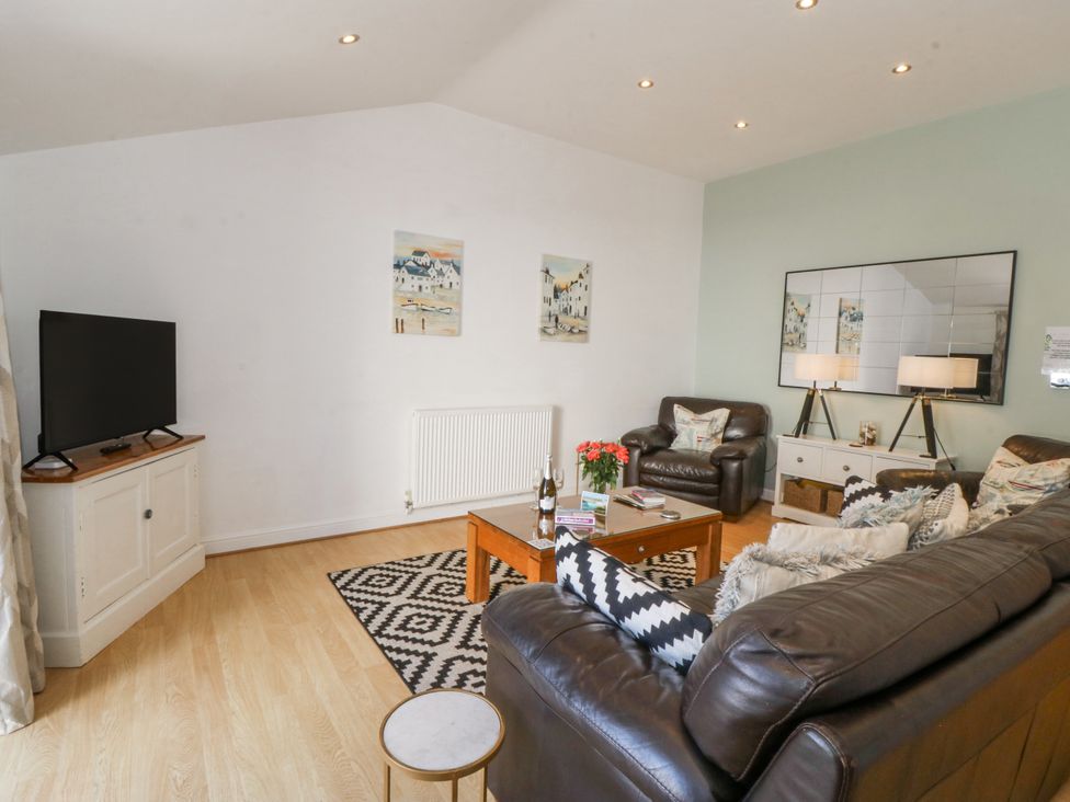 A living room with a television and coffee table at Maritime Mews, 6 The Oakleys in Porthmadog