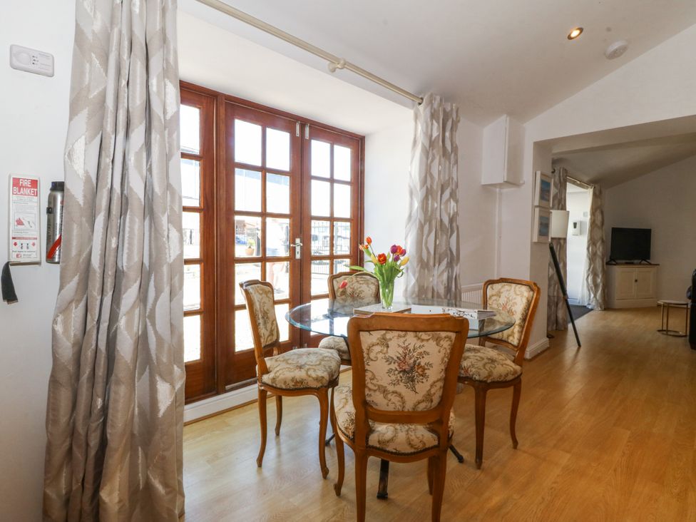 A dining room with a round table and chairs at Maritime Mews, 6 The Oakleys Porthmadog