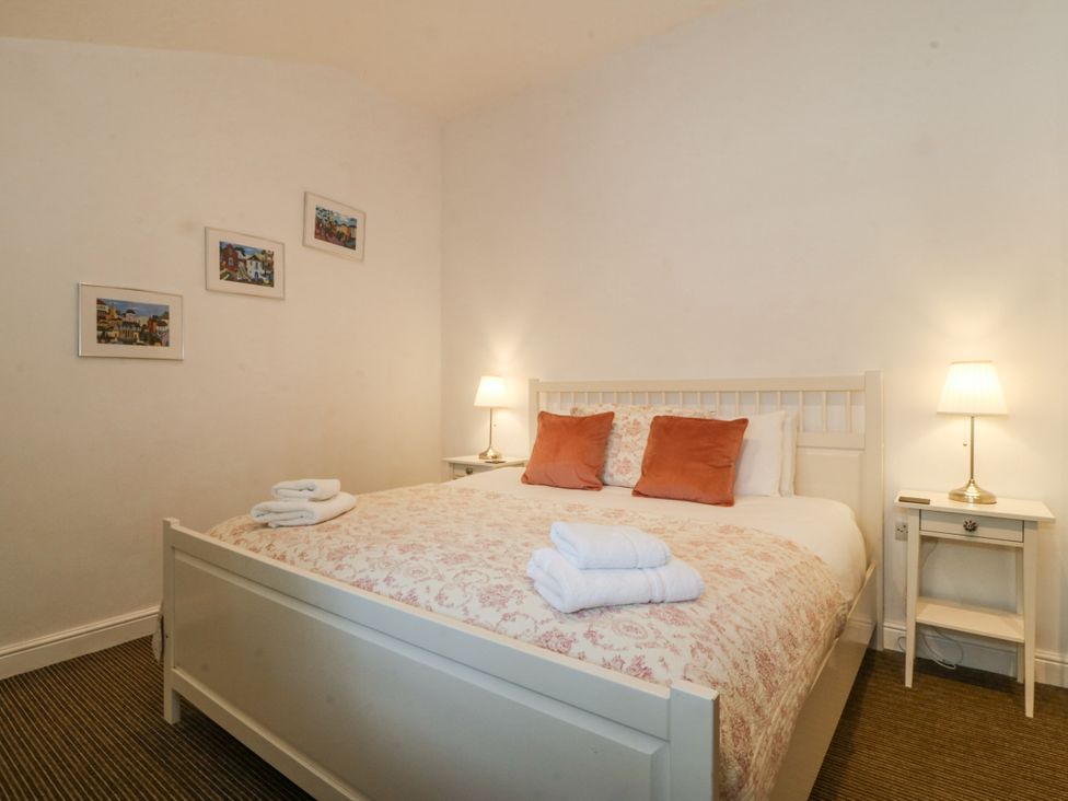 A bedroom with a bed and bedside tables at Maritime Mews, 6 The Oakleys, Porthmadog