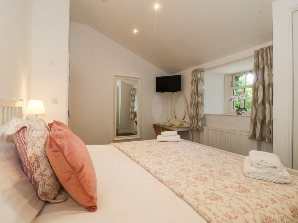 A bedroom with a bed and a mirror at Maritime Mews, 6 The Oakleys, Porthmadog