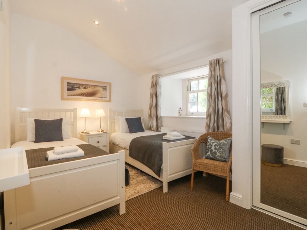 A bedroom with two beds and a window at Maritime Mews, 6 The Oakleys, Porthmadog