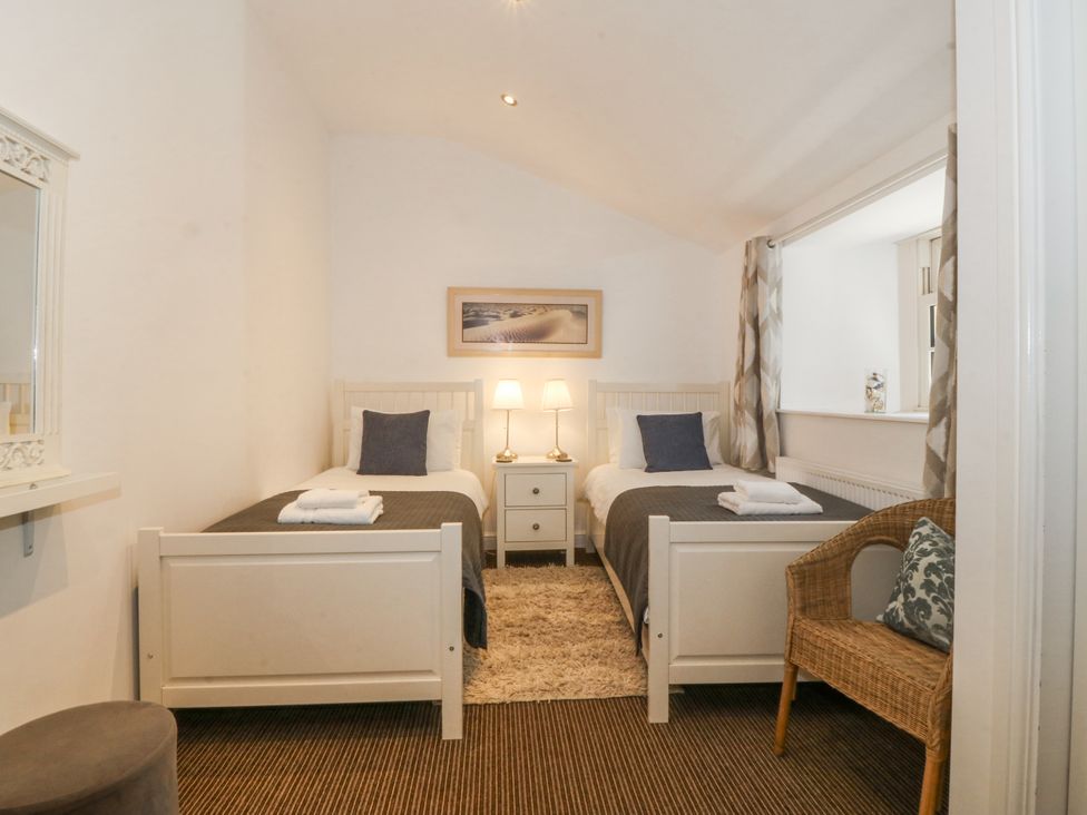 A bedroom with two single beds and a nightstand at Maritime Mews, 6 The Oakleys Porthmadog