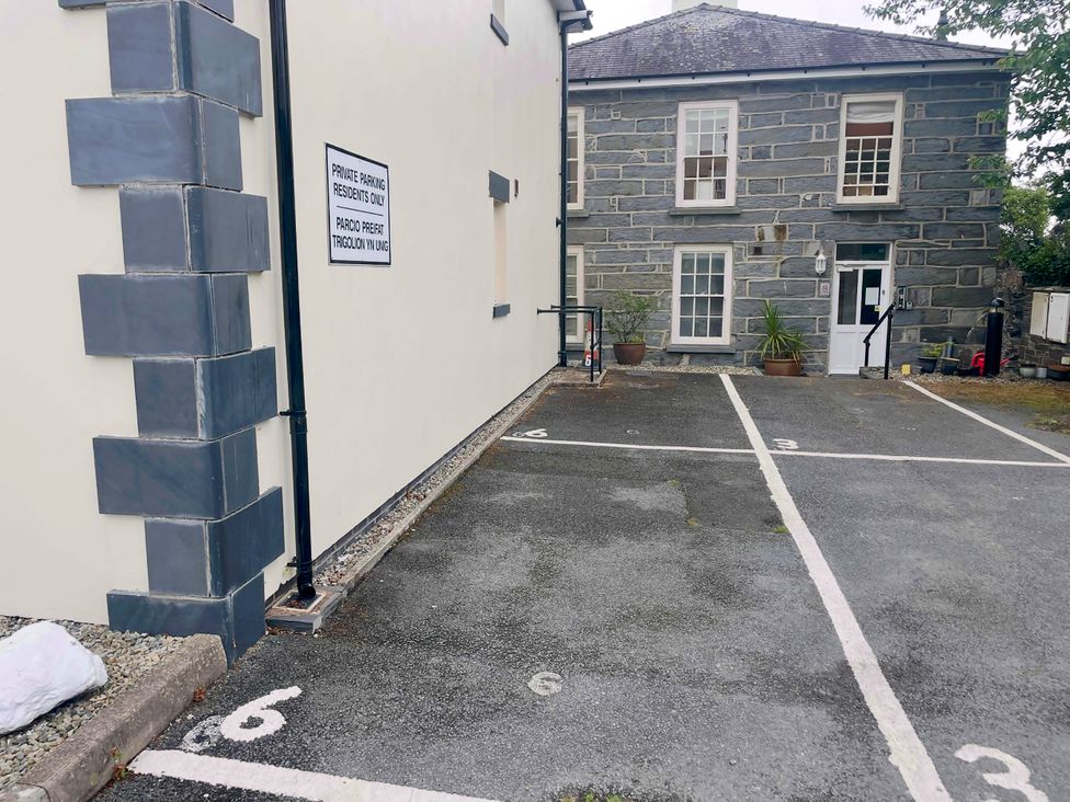 An outdoor parking area with marked spaces and a sign at Maritime Mews, 6 The Oakleys, Porthmadog