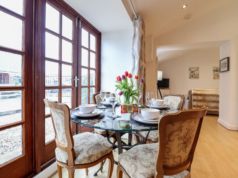 A dining room with window views at Maritime Mews, 6 The Oakleys in Porthmadog