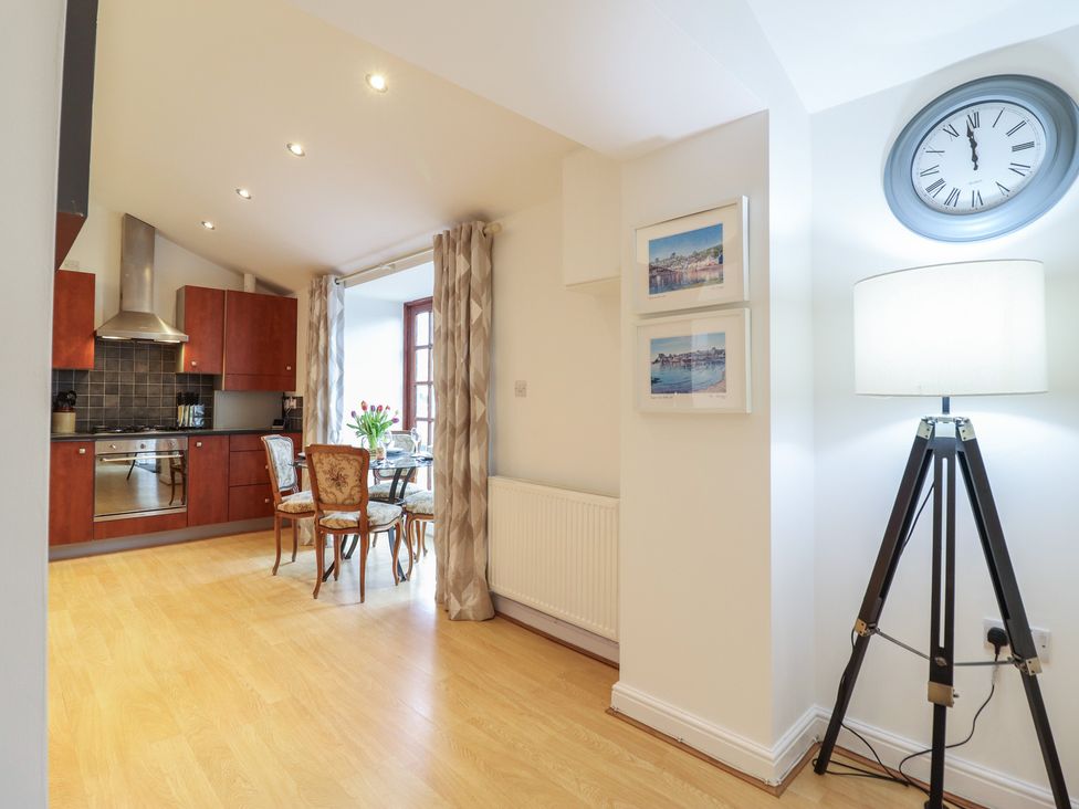 A kitchen with wooden cabinets and dining table at Maritime Mews, 6 The Oakleys in Porthmadog