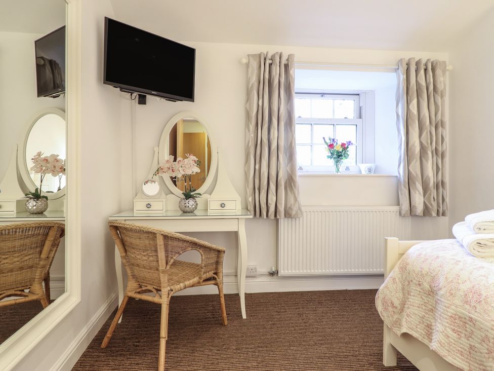 A bedroom with a bed, desk, and television at Maritime Mews, 6 The Oakleys, Porthmadog