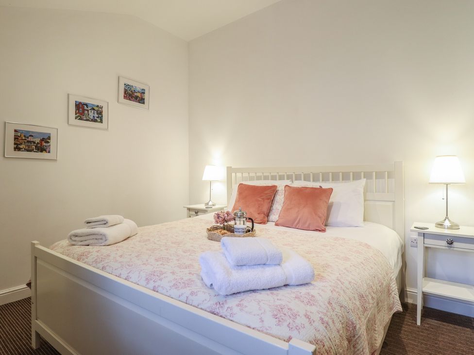 A bedroom with a bed and side table at Maritime Mews, 6 The Oakleys Porthmadog