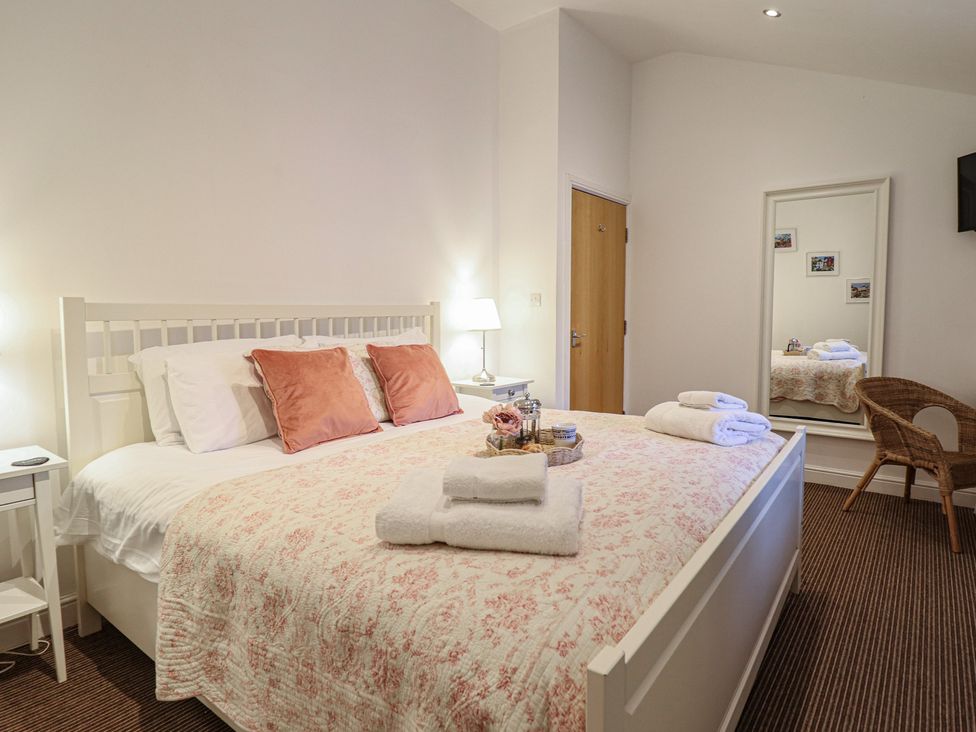 A bedroom with a bed and bedside table at Maritime Mews, 6 The Oakleys, Porthmadog