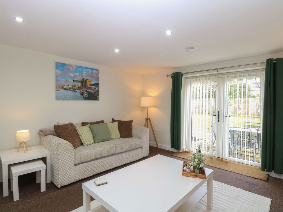 A living room with a sofa and coffee table at Sleepeezy in Little Snoring