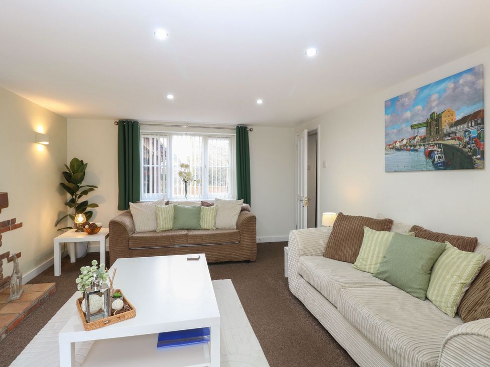 A living room with sofas and a table at Sleepeezy in Little Snoring