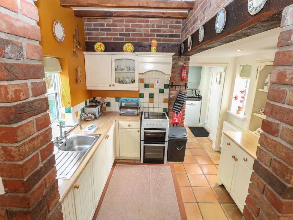 A kitchen with cabinets and a stove at Sleepeezy in Little Snoring