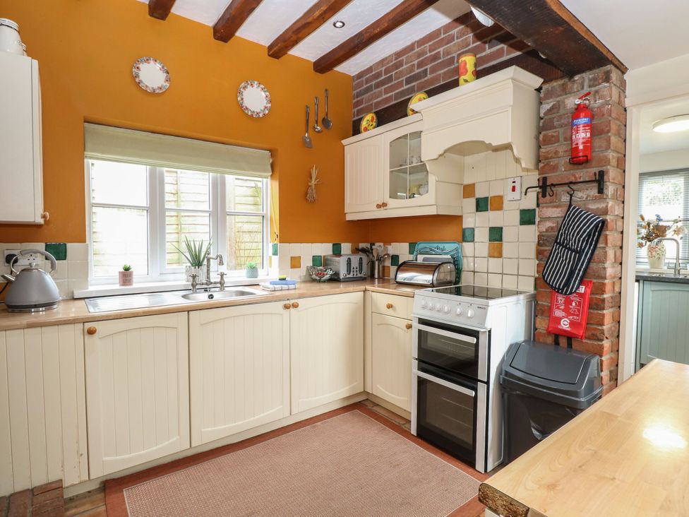 A kitchen with cabinets and a sink at Sleepeezy in Little Snoring