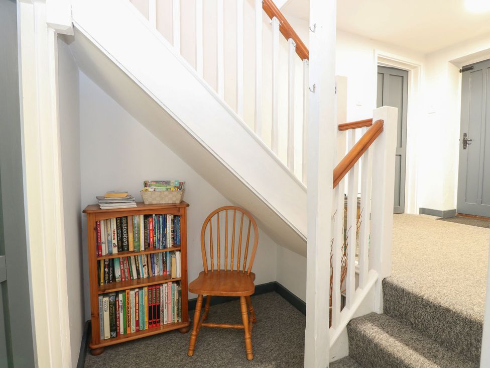 An entrance hall with a bookshelf and a chair at Sleepeezy in Little Snoring