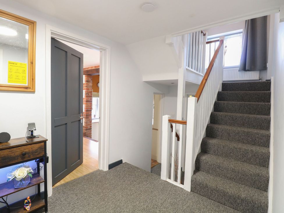 A hallway with a staircase and door at Sleepeezy in Little Snoring