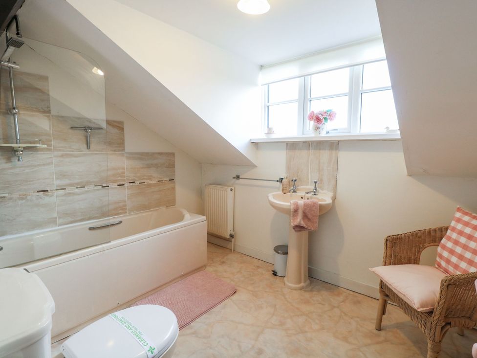 A bathroom with a bathtub and sink at Sleepeezy in Little Snoring