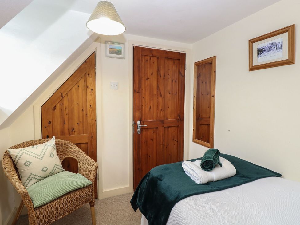 A bedroom with a bed and a chair at Sleepeezy in Little Snoring