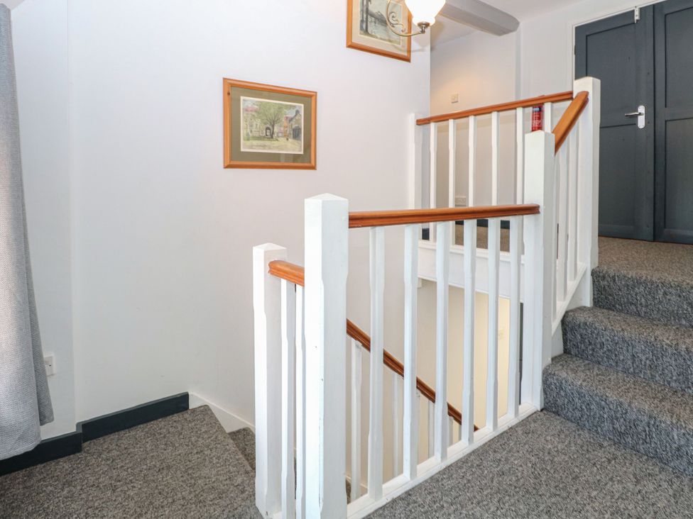 A staircase with carpet and framed pictures at Sleepeezy in Little Snoring