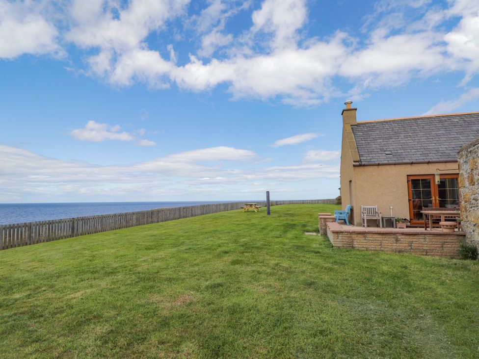 An outdoor area with a house and ocean view at Braehead Croft Portessie near Buckie