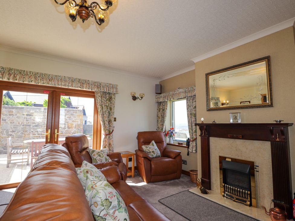 A living room with a sofa and armchair at Braehead Croft Portessie near Buckie