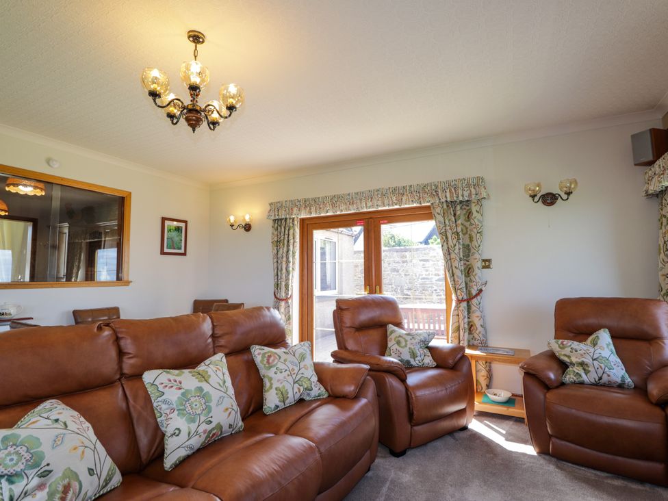 A living room with sofa and chairs at Braehead Croft in Portessie near Buckie