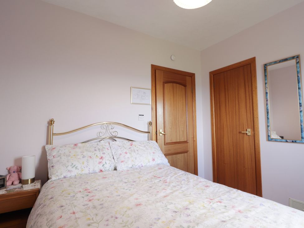 A bedroom with a bed and wooden furniture at Braehead Croft Portessie near Buckie
