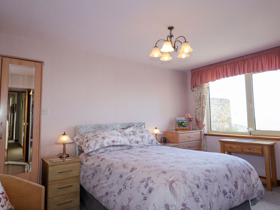 A bedroom with a bed and nightstand at Braehead Croft in Portessie near Buckie