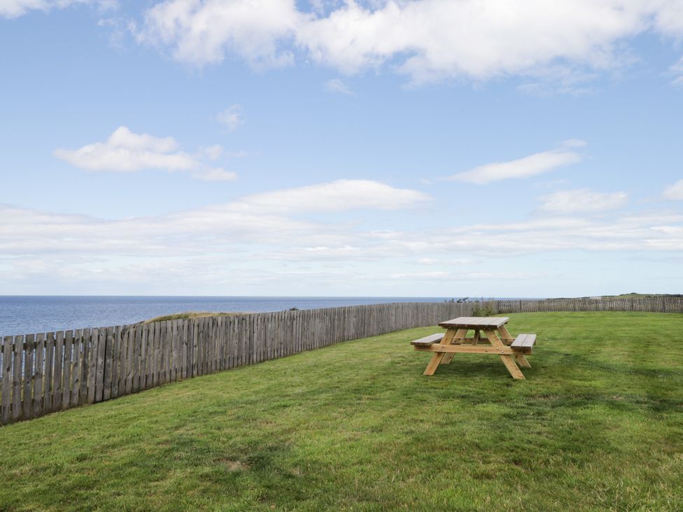 A garden with a picnic table overlooking the ocean at Braehead Croft in Portessie near Buckie