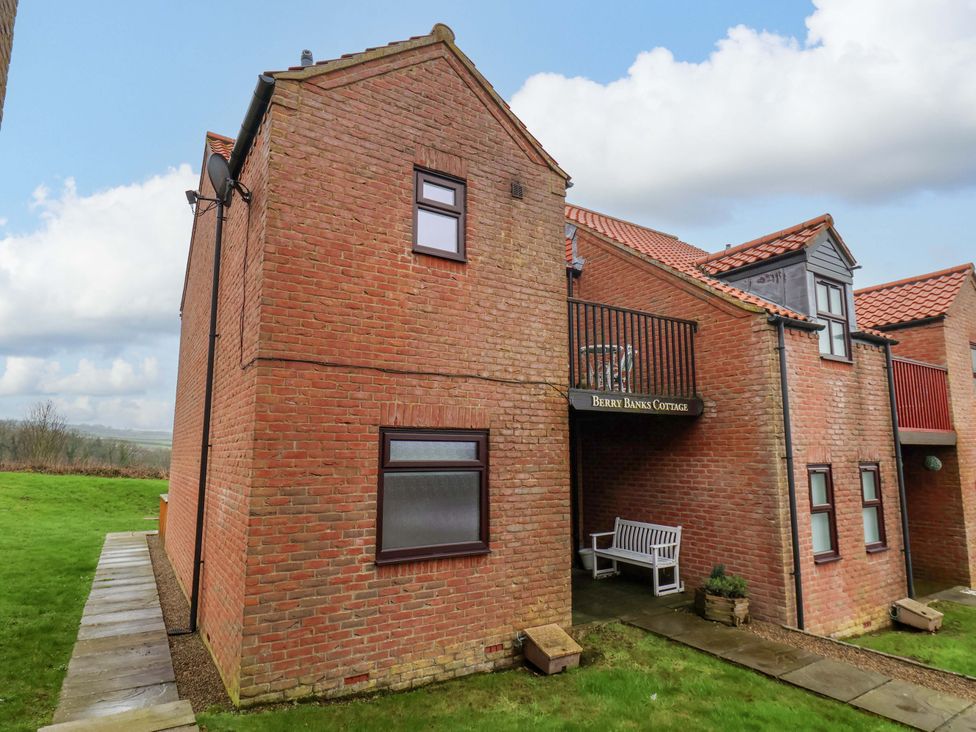 An outdoor view of a cottage with a balcony at Berry Banks Cottage in Whitby