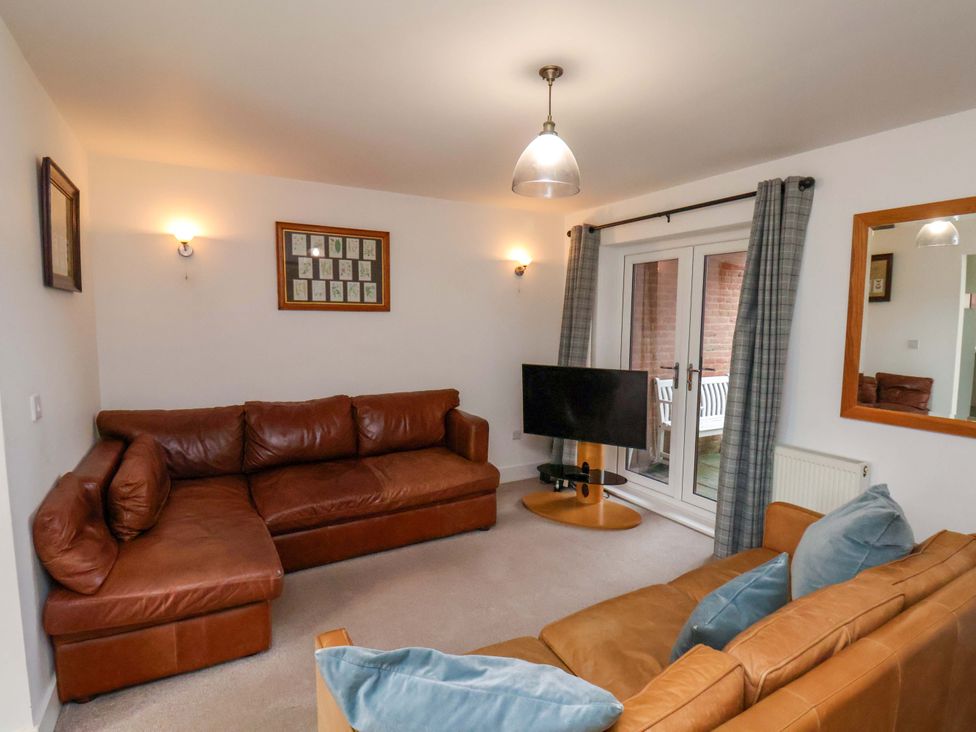 A living room with a sofa and television at Berry Banks Cottage in Whitby