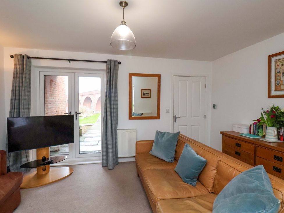 A living room with a sofa and television at Berry Banks Cottage in Whitby