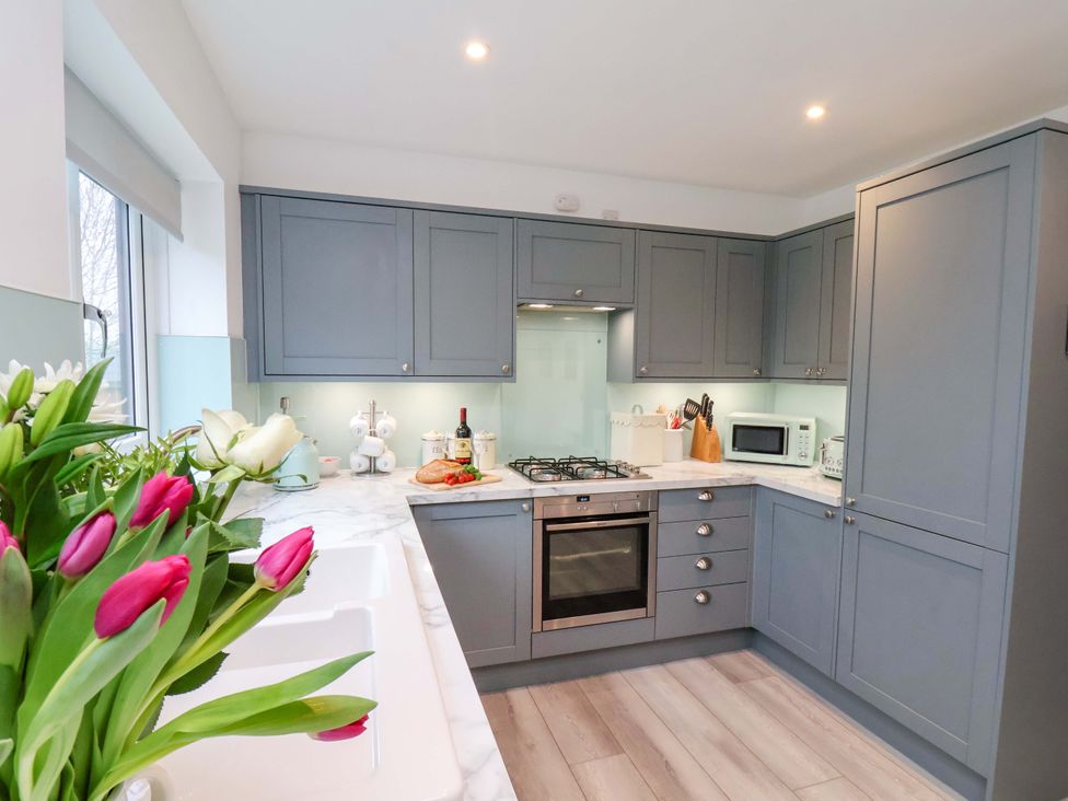 A kitchen with cabinets and appliances at Berry Banks Cottage in Whitby