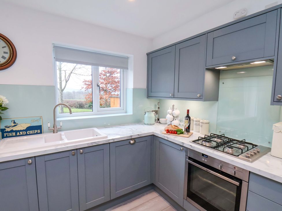A kitchen with a sink, stove, and cabinets at Berry Banks Cottage in Whitby