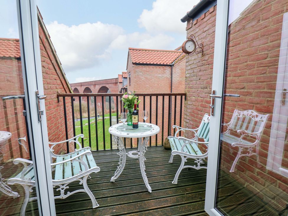A balcony with a table and chairs at Berry Banks Cottage in Whitby