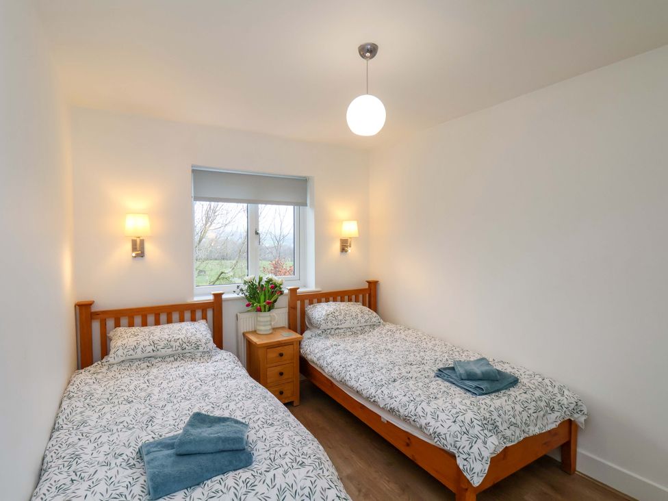 A bedroom with two beds and a window at Berry Banks Cottage in Whitby