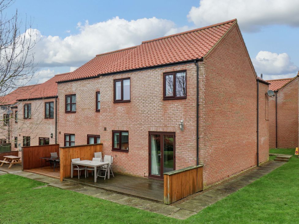 A house with a deck and table at Berry Banks Cottage in Whitby