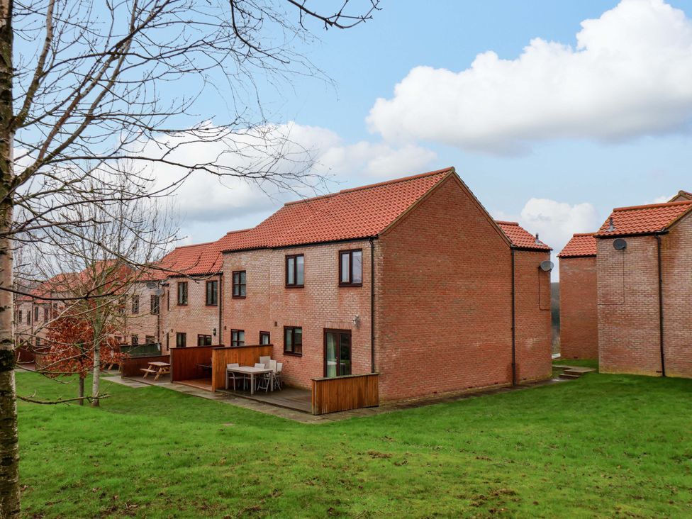 A row of houses with a patio and grass area at Berry Banks Cottage in Whitby