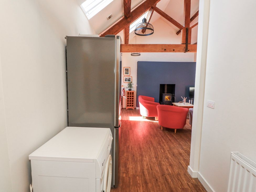 A living room with a fridge and dining area at Hen Blas in Aberdaron
