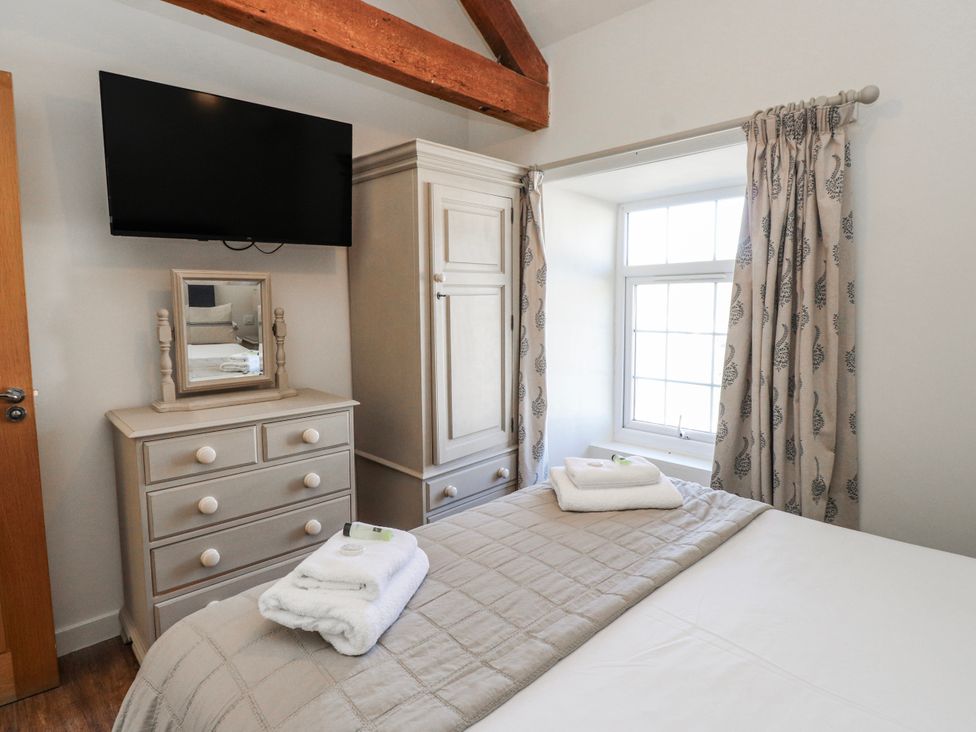 A bedroom with a television and a dresser at Hen Blas in Aberdaron
