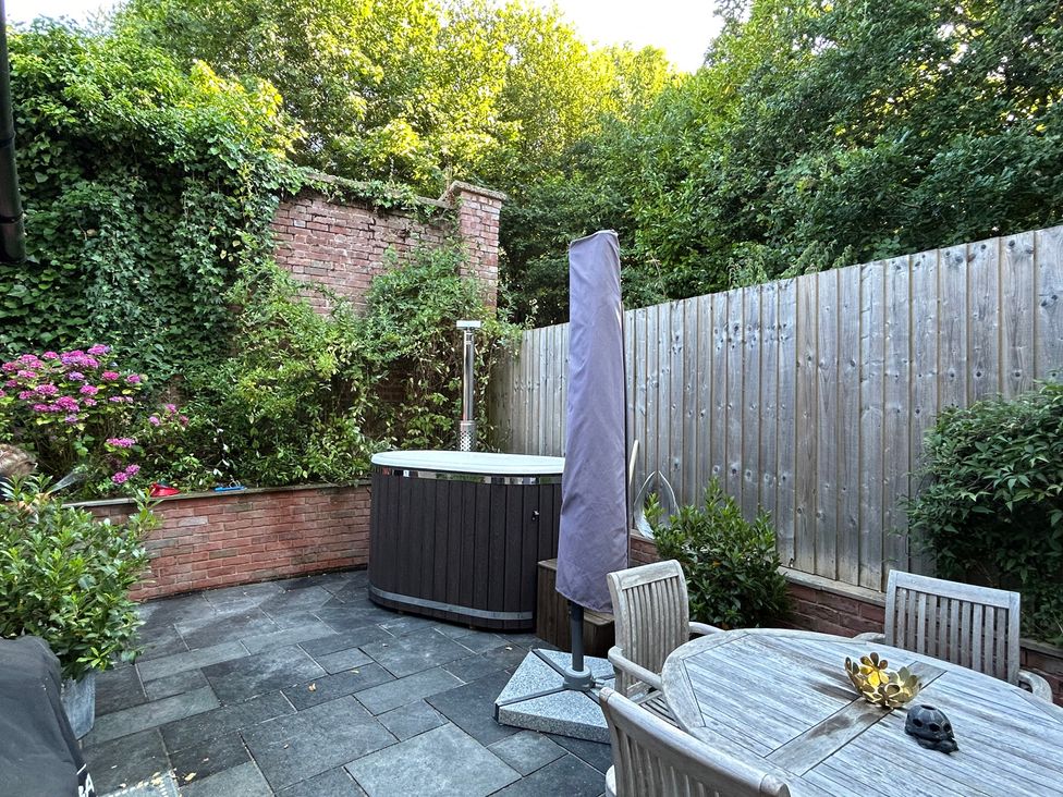 A garden with a hot tub and seating area at Treetops in Southerton near Sidmouth