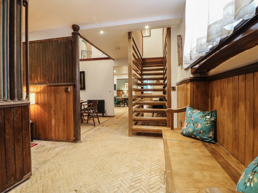 An entrance hall with a staircase and wood bench at Shrewsbury Lodge Great Haywood