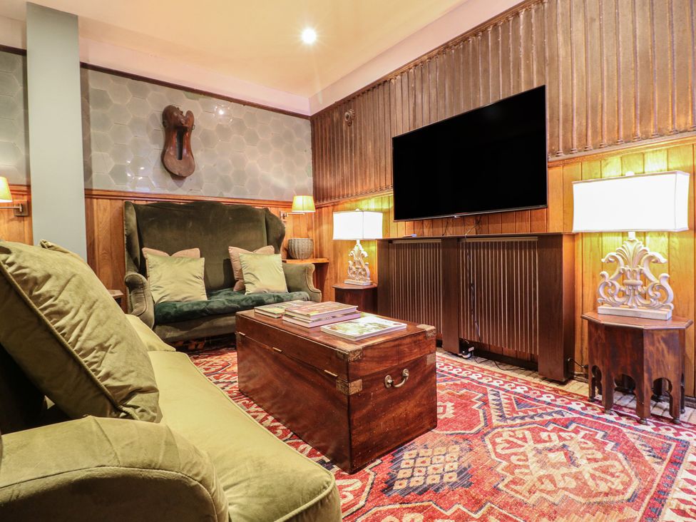 A living room with a sofa and a television at Shrewsbury Lodge in Great Haywood