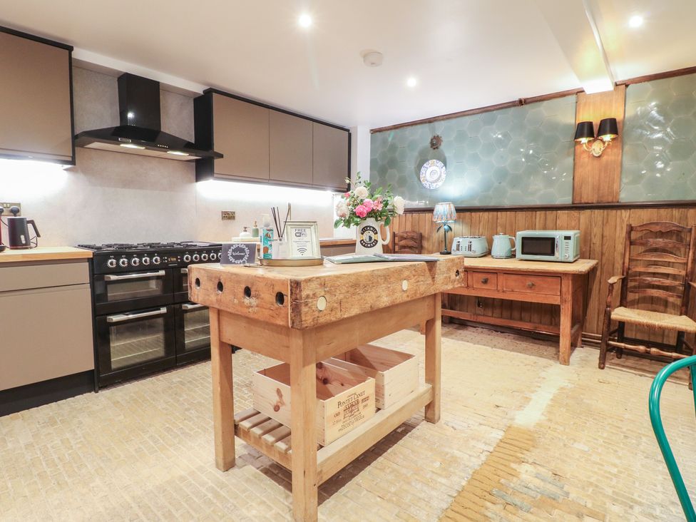A kitchen with a stovetop and wooden island at Shrewsbury Lodge in Great Haywood